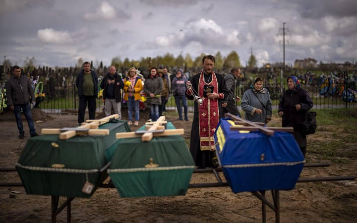 Fotovýber: Kňaz vykonáva pohrebný obrad v ukrajinskej Buči, kde zomreli civilist