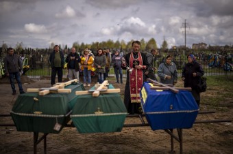 Fotovýber: Kňaz vykonáva pohrebný obrad v ukrajinskej Buči, kde zomreli civilist