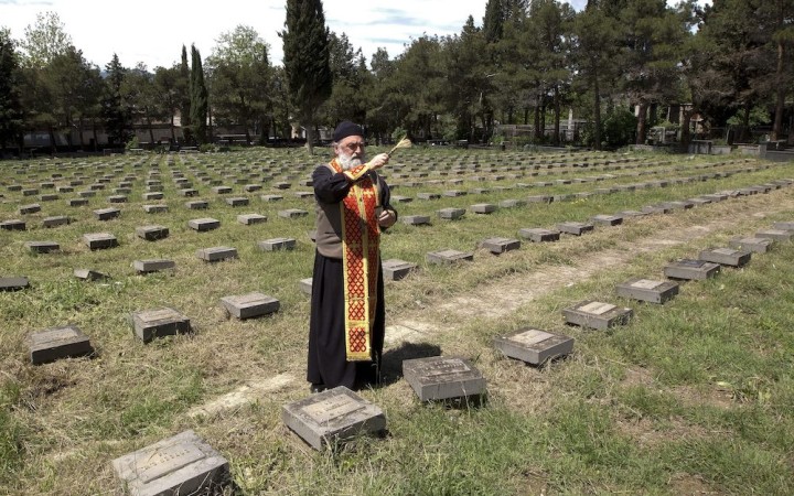 Fotovýber: Gruzínsky pravoslávny kňaz požehnáva hroby na cintoríne v Tbilisi
