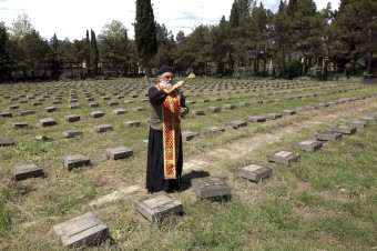 Fotovýber: Gruzínsky pravoslávny kňaz požehnáva hroby na cintoríne v Tbilisi