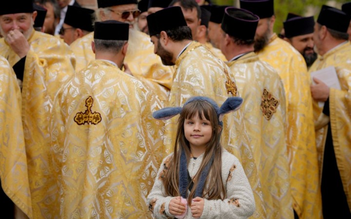 Fotovýber: Dievčatko pózuje pred skupinou kňazov počas slávenia pravoslávnej Kve