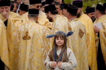 Fotovýber: Dievčatko pózuje pred skupinou kňazov počas slávenia pravoslávnej Kve