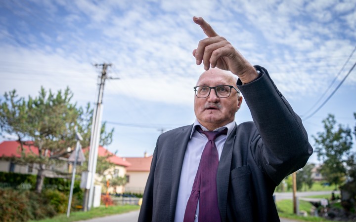 Muž v staršom veku kráčajúci v obleku po Očovej na prvý pohľad vyzerá, akoby šie